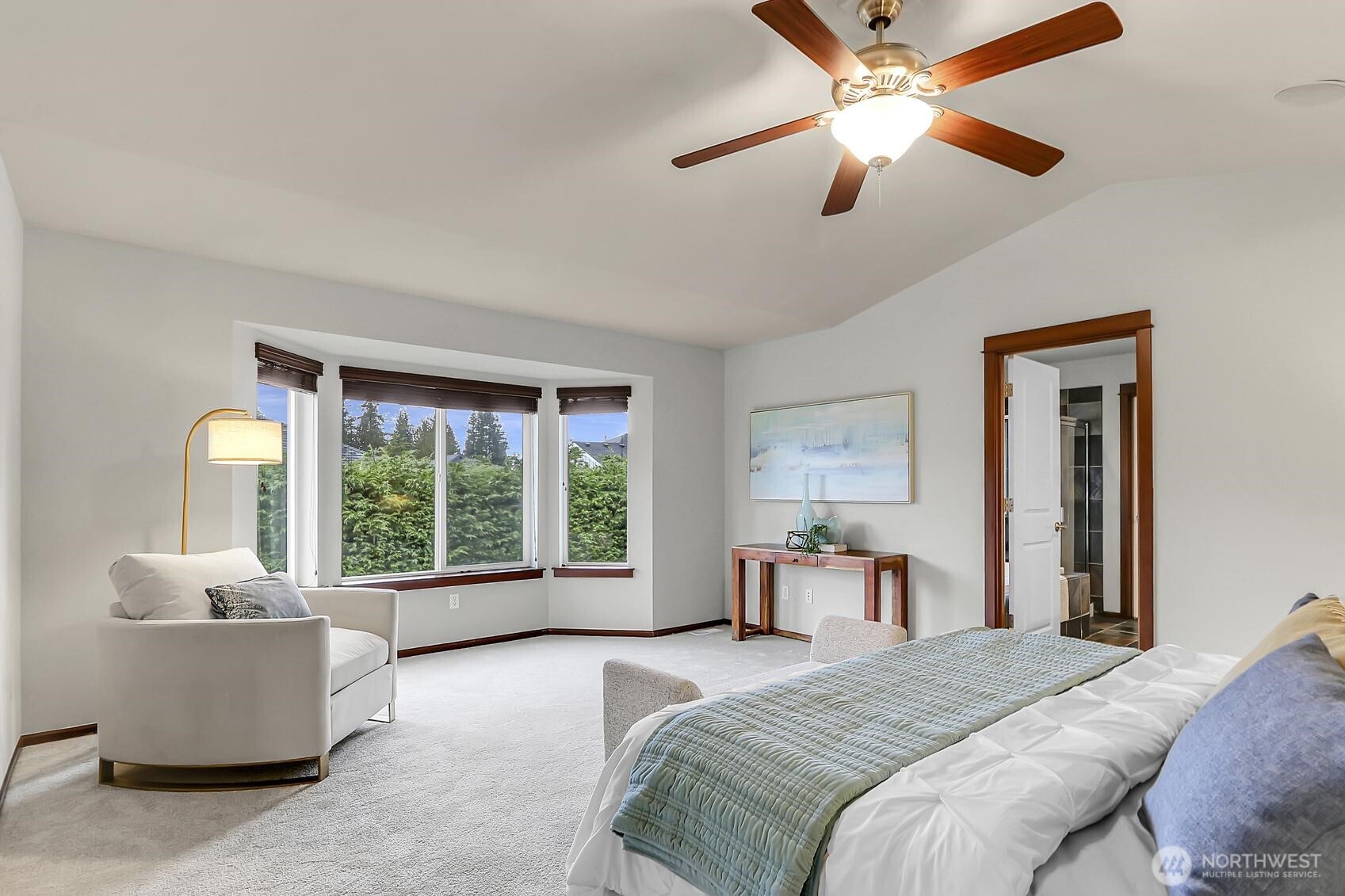 Primary suite with vaulted ceiling and a cozy sitting area.