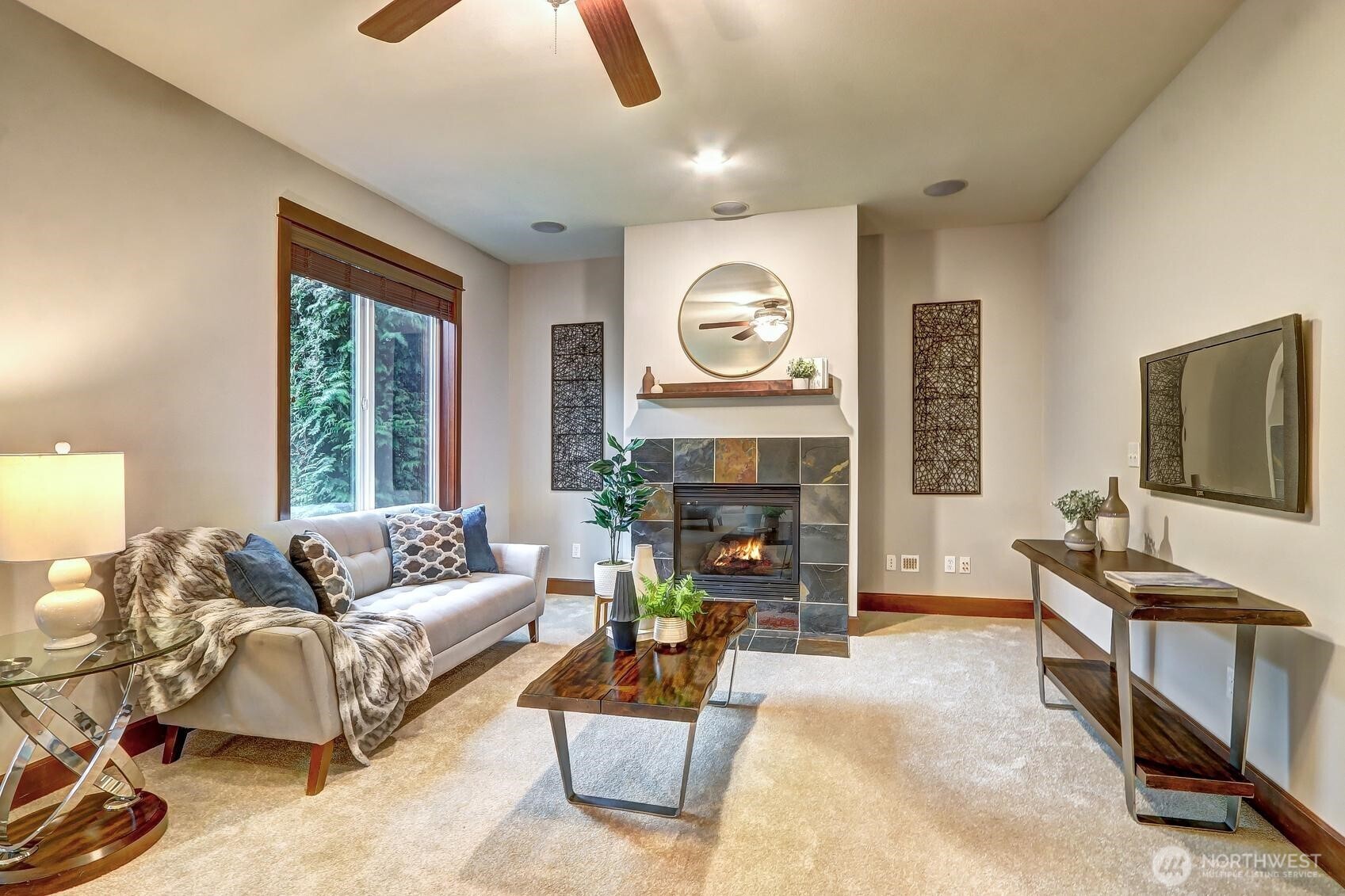 Comfortable family room with a ceiling fan and gas fireplace.