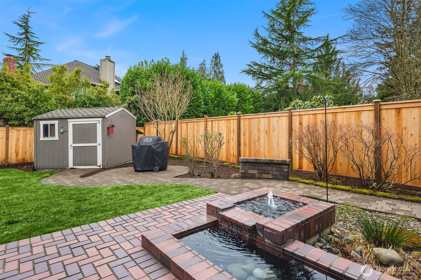 This yard has so much to offer. Water feature, outbuilding/shed, fort (behind the shed), new fence and more