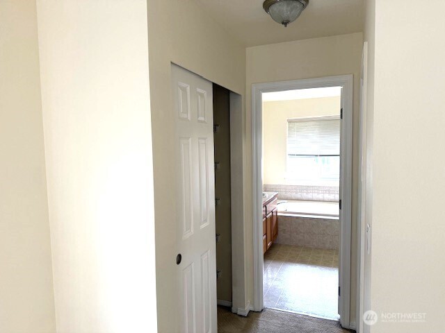 Primary Room Hallway to Bathroom - shelving closet on left, WIC on right