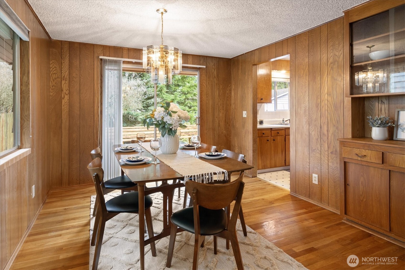 Kitchen and dining room spill out onto expansive deck overlooking woodland garden.