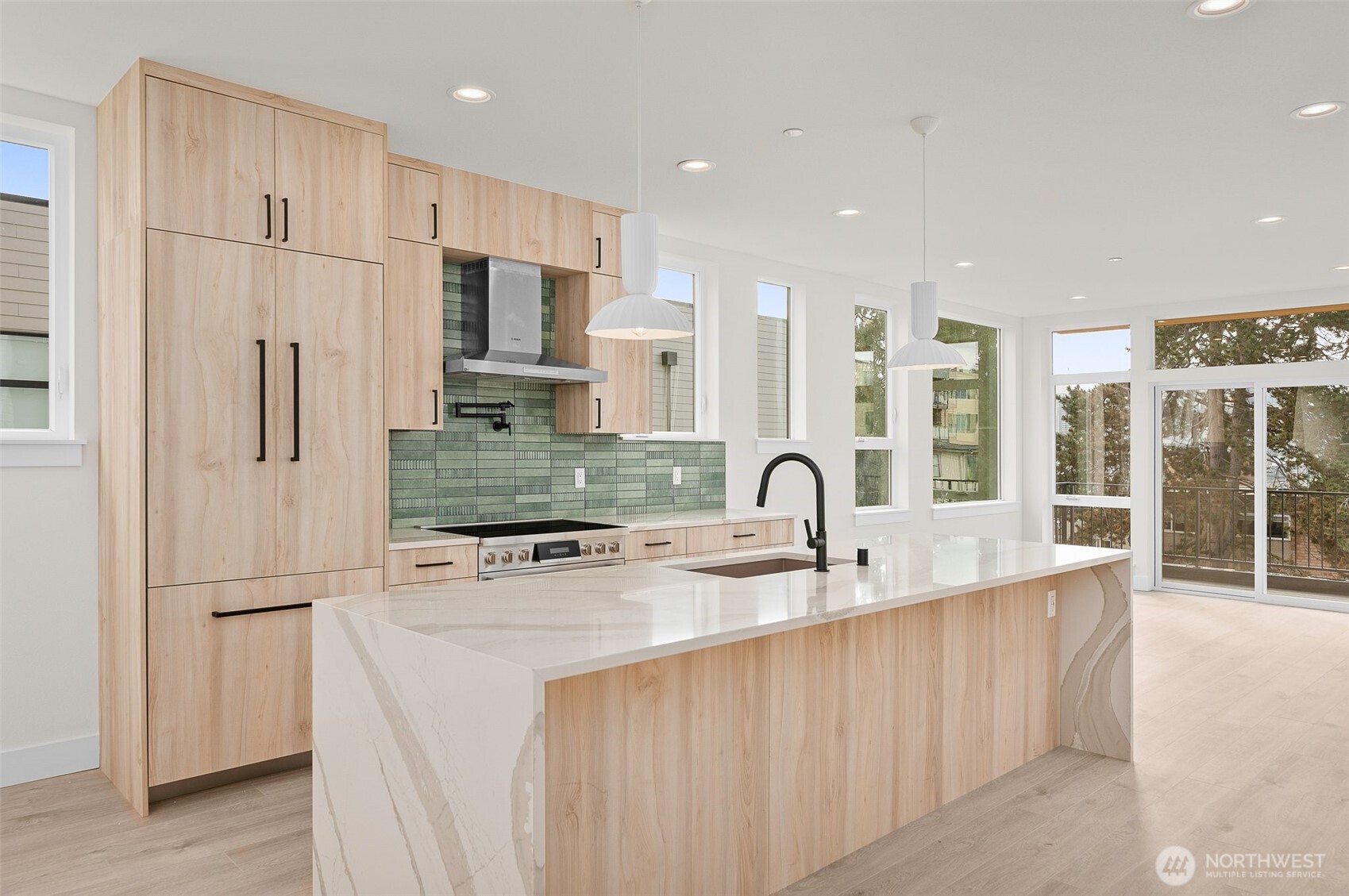 Black hardware complements the light wood cabinetry & stainless steel appliances.