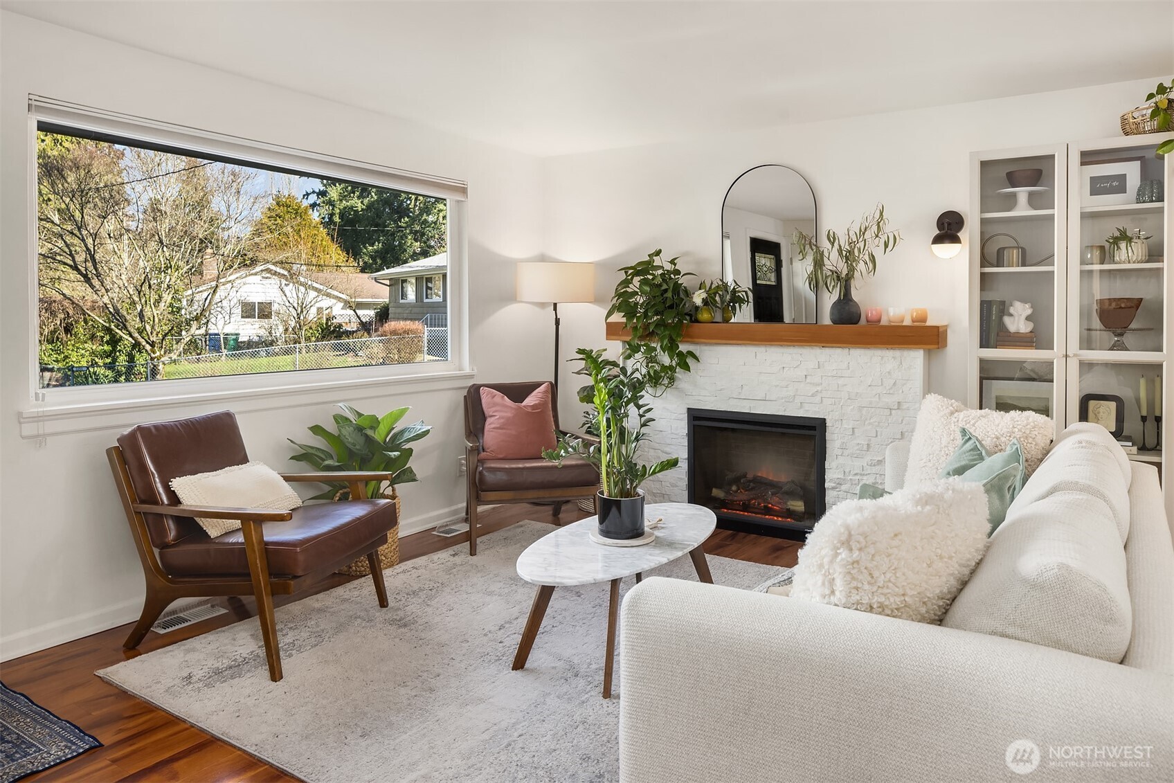 Bright living room with a large window complemented by fireplace and open layout.