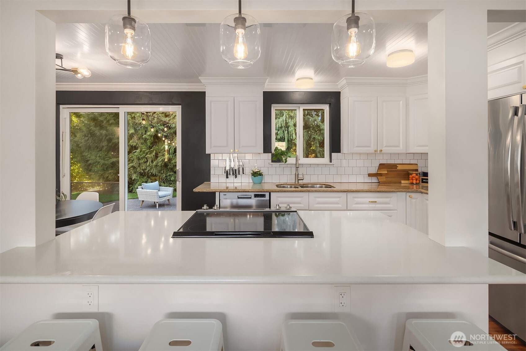 Bright kitchen with modern appliances and view of outdoor space through sliding glass doors.