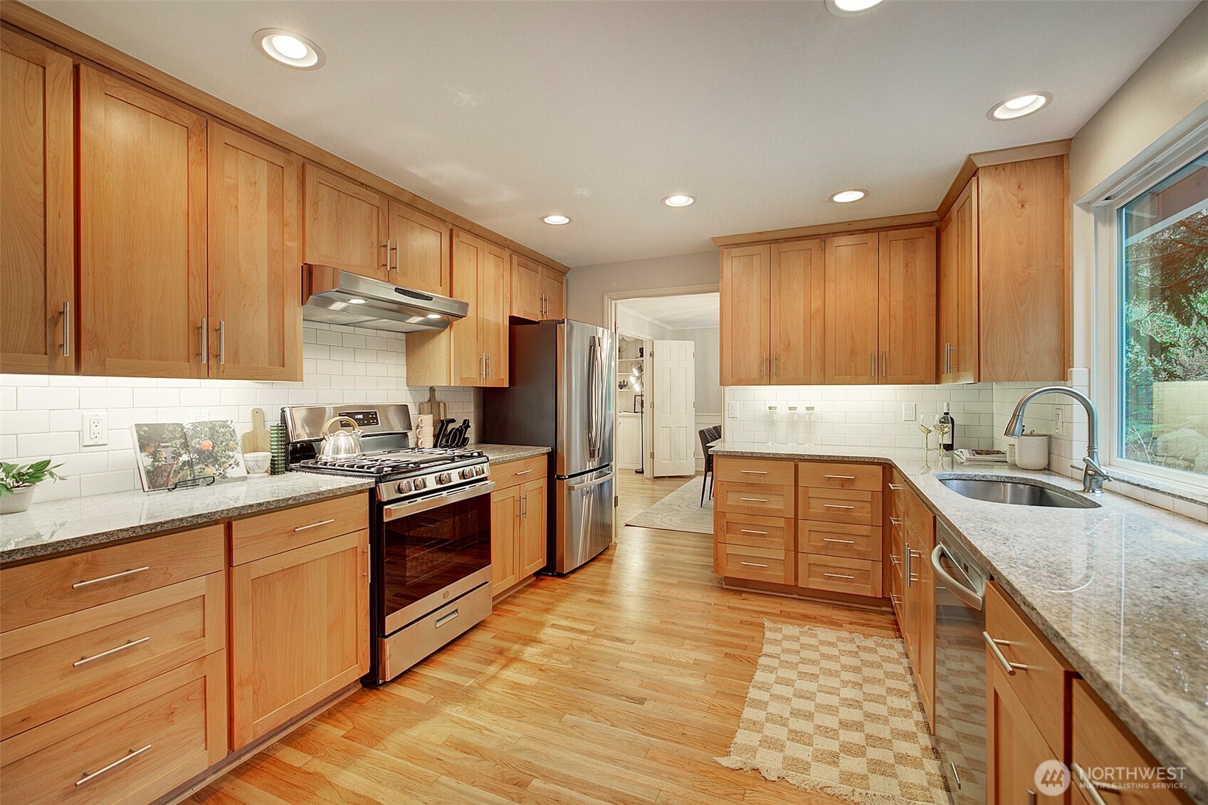 Kitchen finishes include alder cabinetry, stainless appliances and slab granite counters.