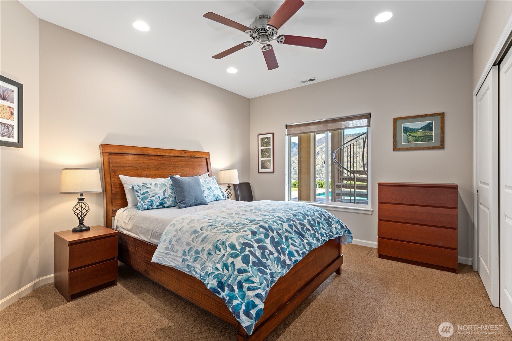 View of lower level bedroom 3 with queen sized bed overlooking the lower patio with pool and private spa.