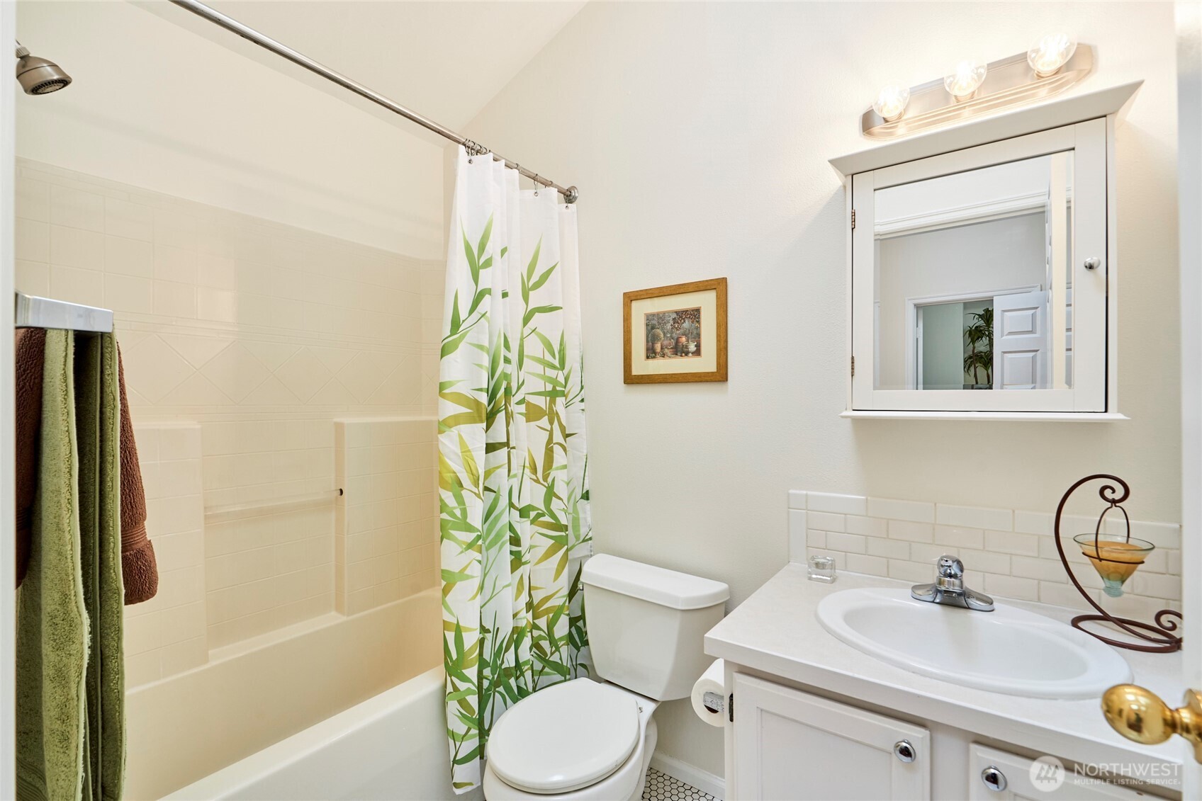 The full bathroom upstairs offers a hex tile floor, subway tile backsplash, new light fixture and a skylight.