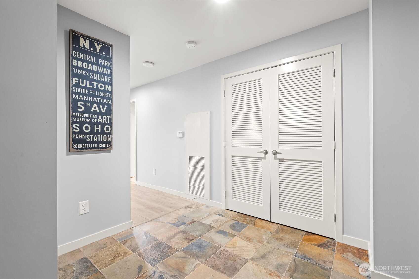 The louvered doors open to the laundry center, where there is extra space for more storage.