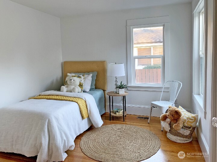 Another view of the back bedroom. The door that connects to the middle bedroom is to the left in the photo. You also get a glimpse of the glass door knobs seen on the right side in this photo. Notice how the hardwood floors reflect the light into the room.