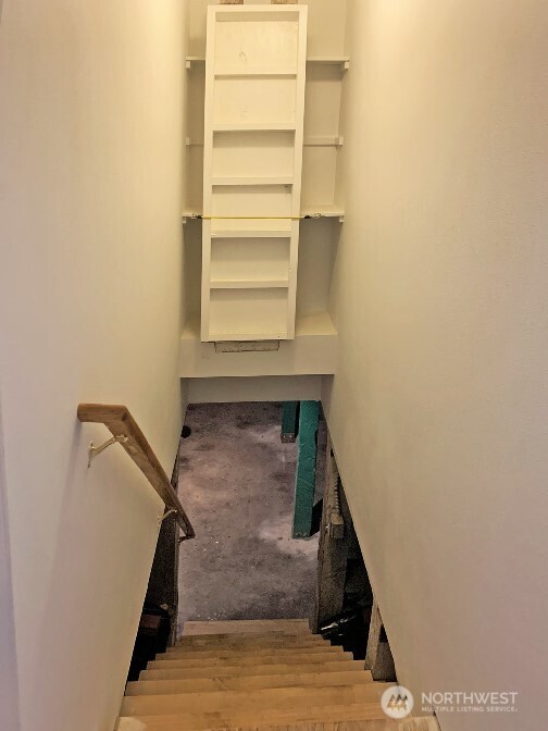 The inside stairs to the partial basement. Notice the brighter object above the stairs,   pulls down to access the storage shelves behind it.