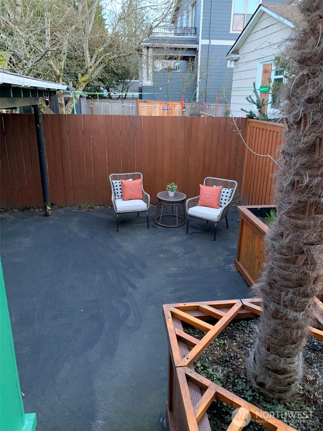 Fully fenced, no maintenance back yard with large potted plants.