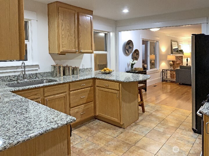 Another view of the kitchen, eating bar and opening to the living room and dining area.