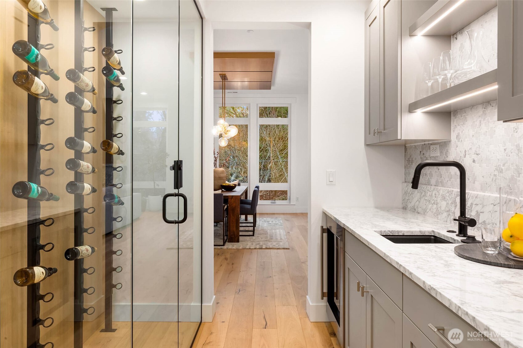 Butlers Pantry off Dining with wet bar and statement wine room with framless glass enclosure and custom rift oak back wall