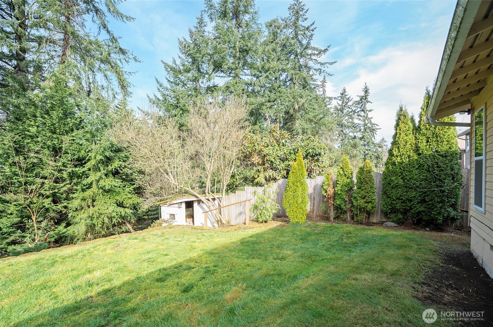 Fully fenced backyard with a storage shed tucked in the corner for added space.