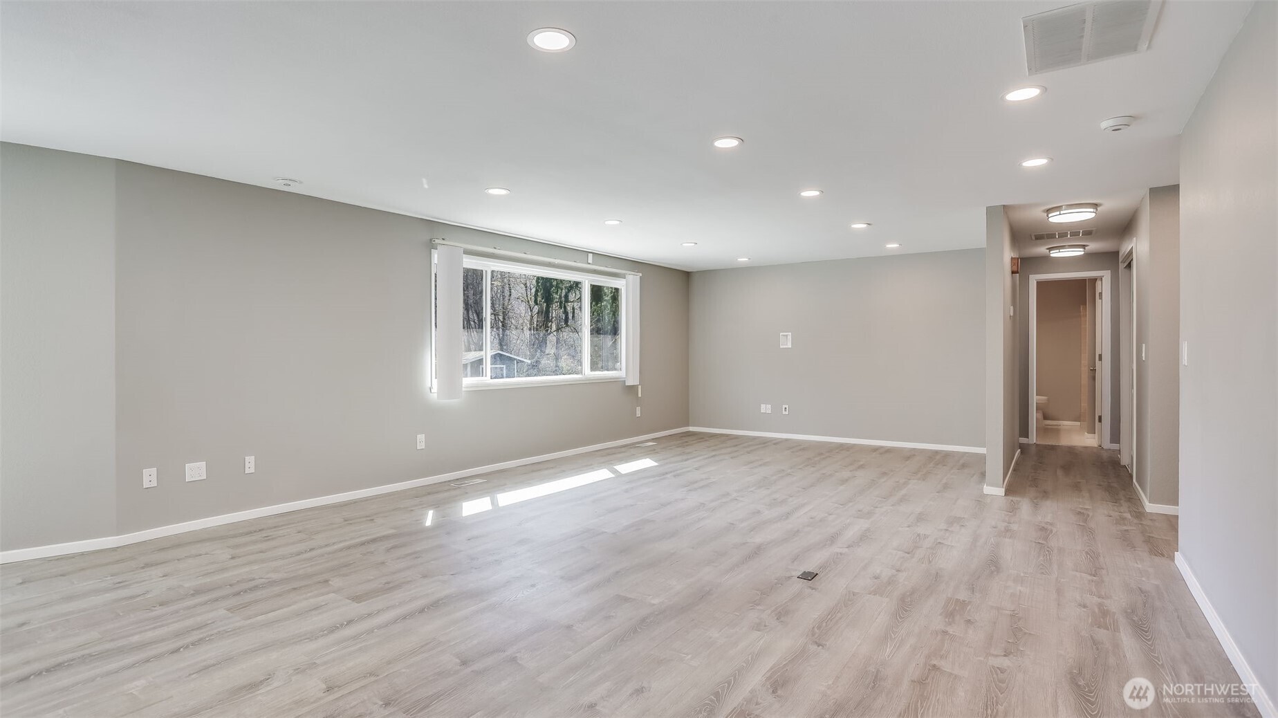 Another angle of this spacious great room offering ample natural light.