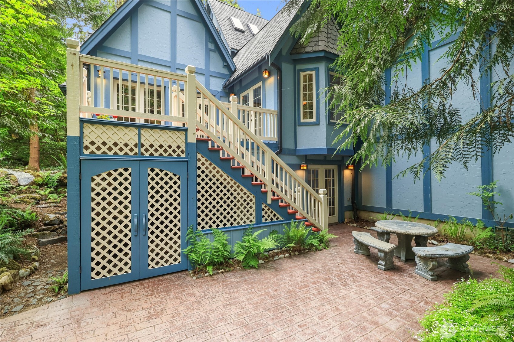 Back deck overlooks the lush scenery and leads to a patio down below. Storage underneath deck.