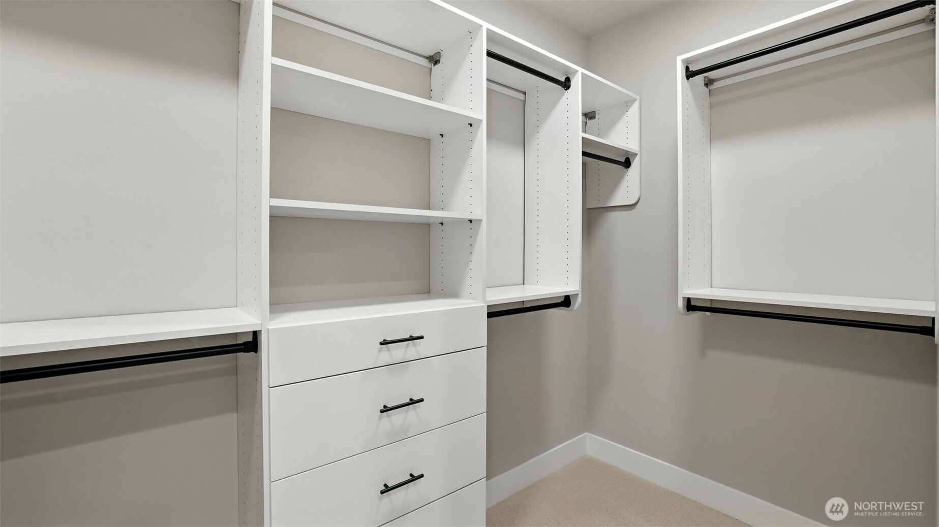 One of two massive walk-in closets of the Primary Suite. Custom wood racks in all of the closets (no wire racks in this house!)