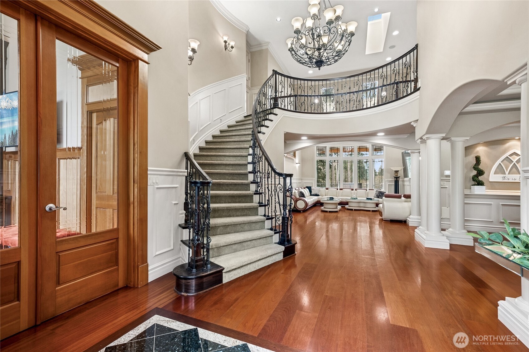 This grand foyer showcases a stunning curved staircase, soaring ceilings, and an exquisite dome coffer detail—blending architectural artistry with timeless elegance.