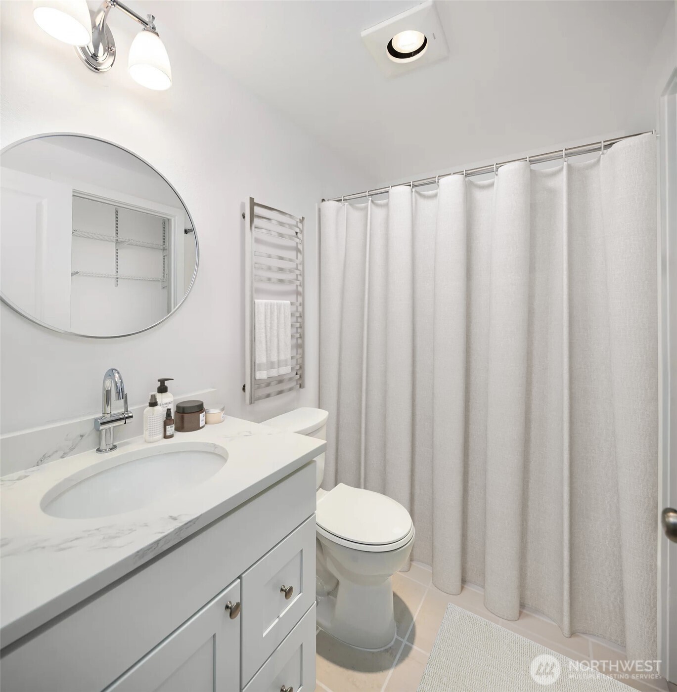 The large bathroom includes a new bath vanity, sink, quartz countertop, toilet and refreshed ceramic tile surround and bath floor.