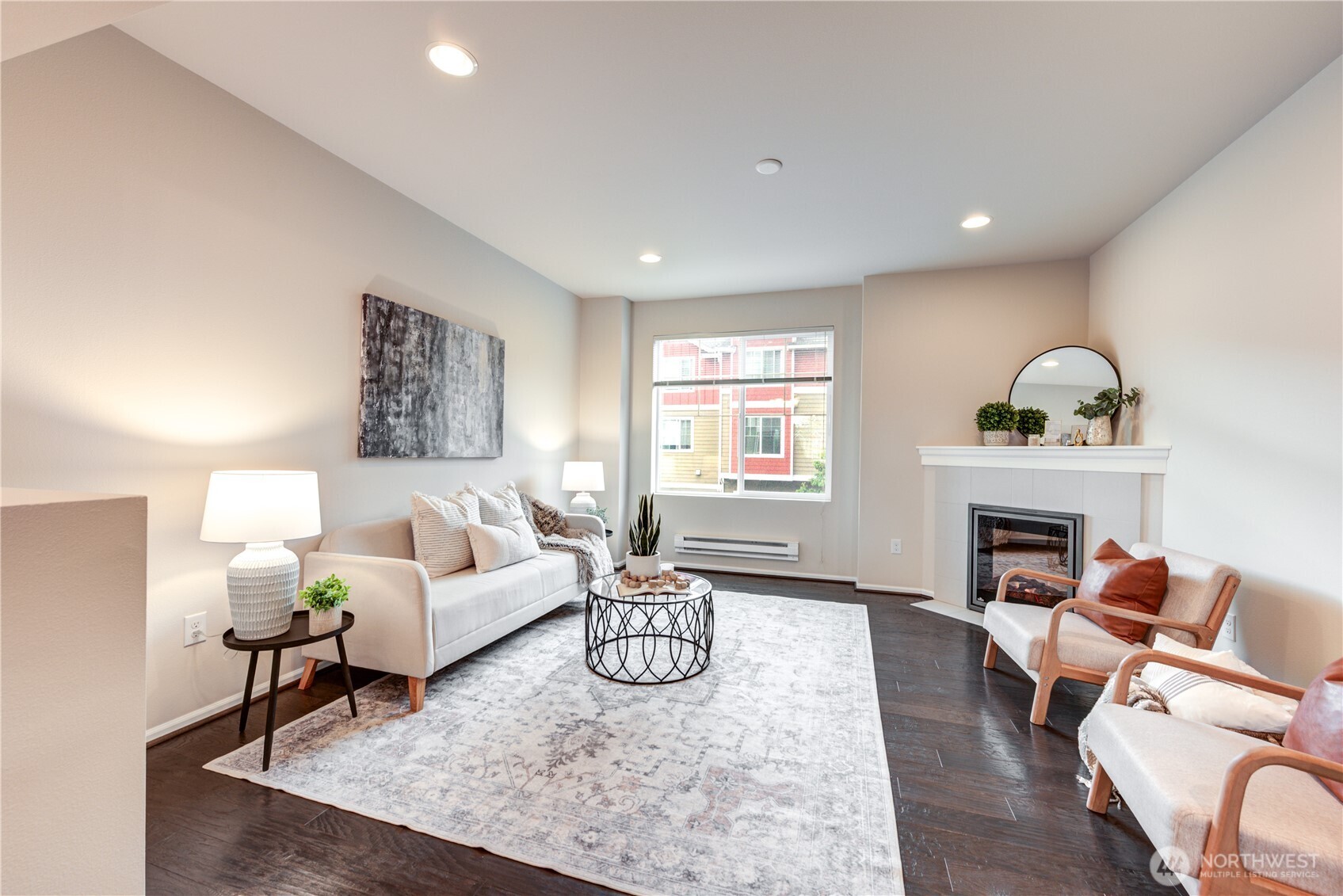 Living room with tall ceilings, engineered hardwood flooring & a fireplace.