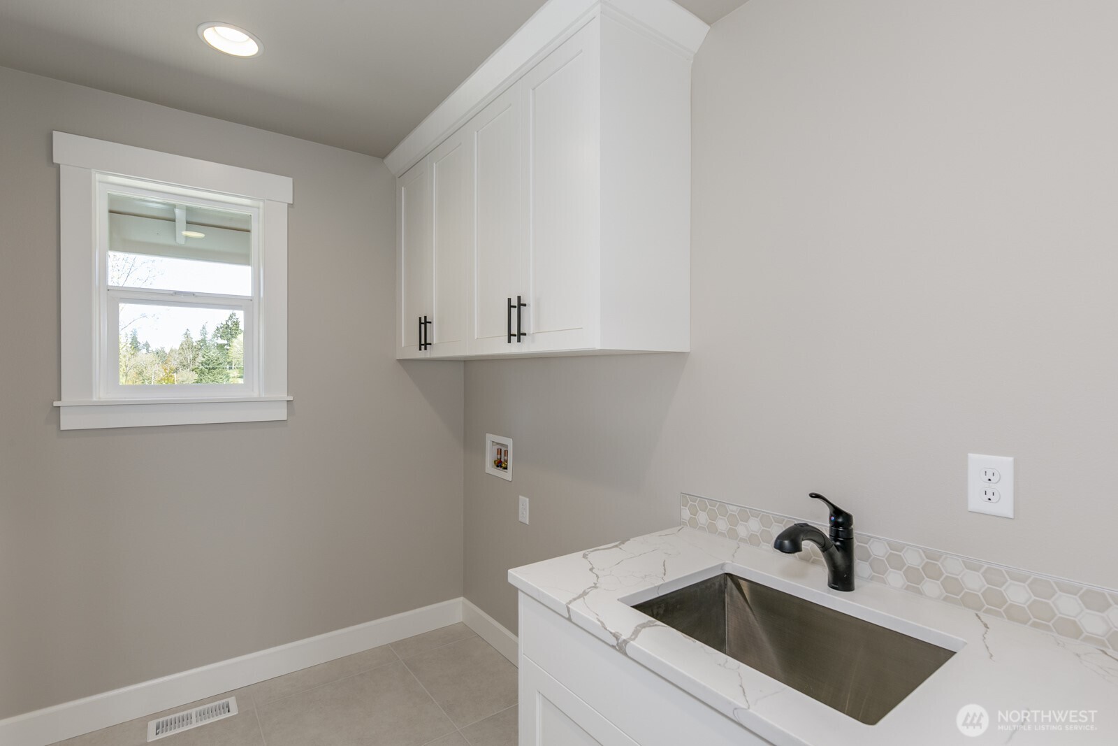 Deluxe laundry room with sink, cabinets & window.