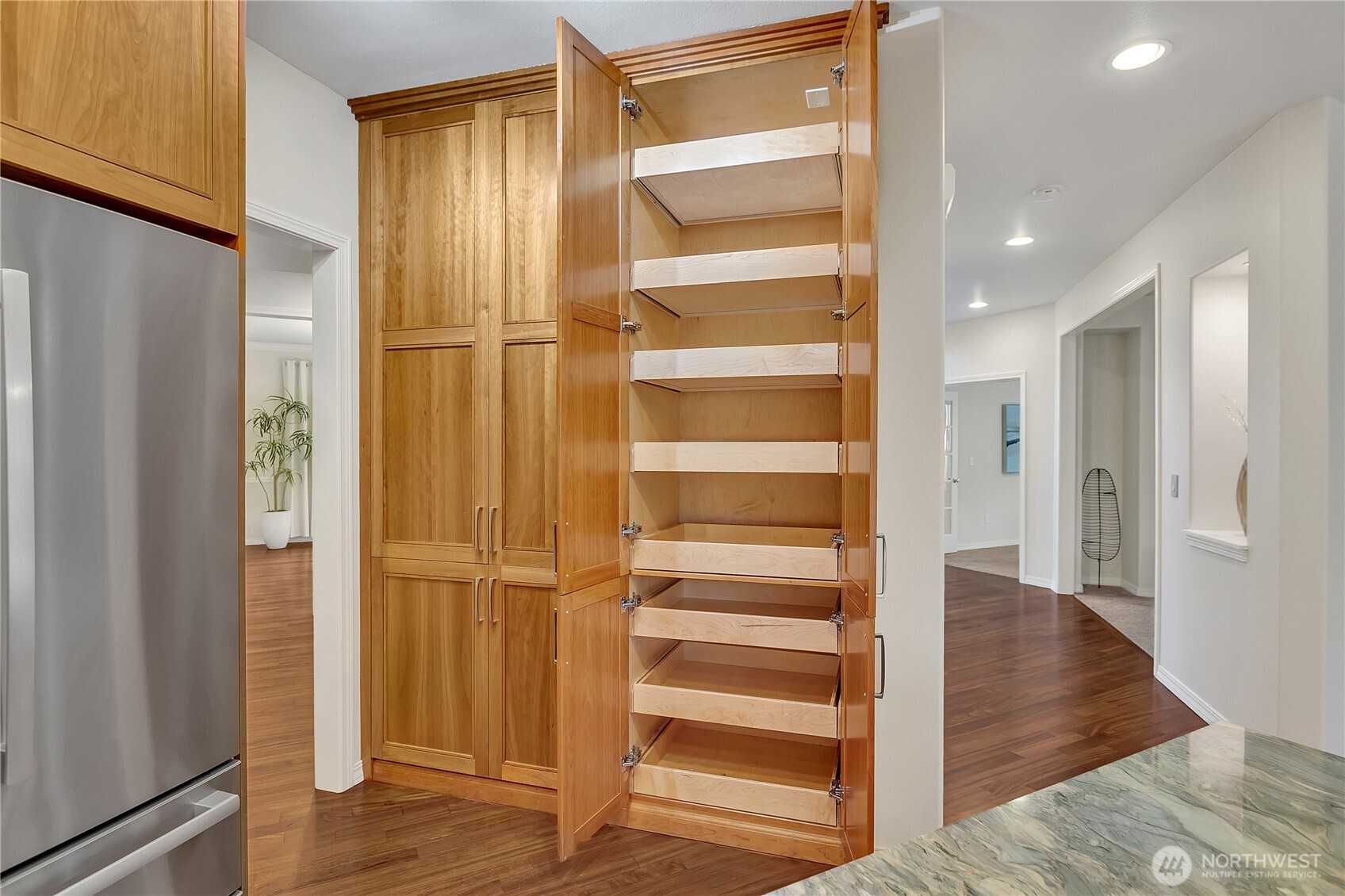 Impressive floor-to-ceiling built-in pantry featuring convenient pull-out shelves for optimal storage and organization.