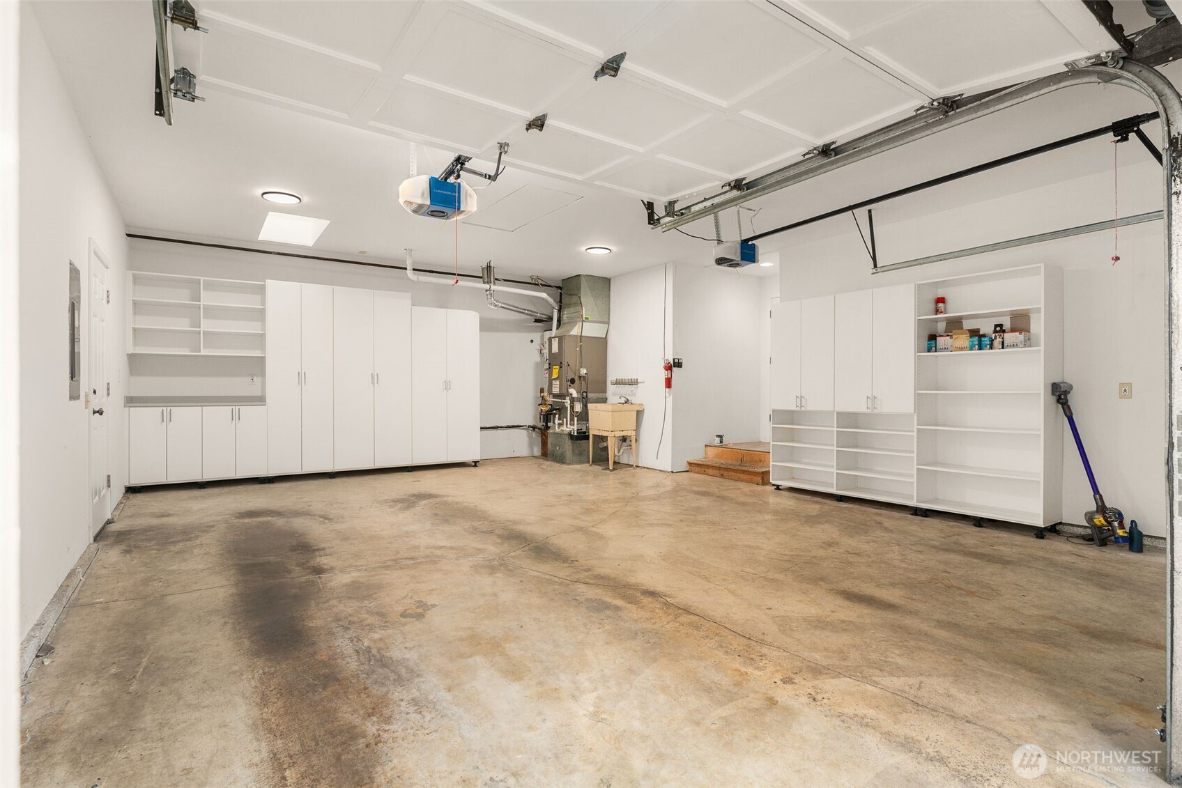 Large garage with custom cabinetry and storage