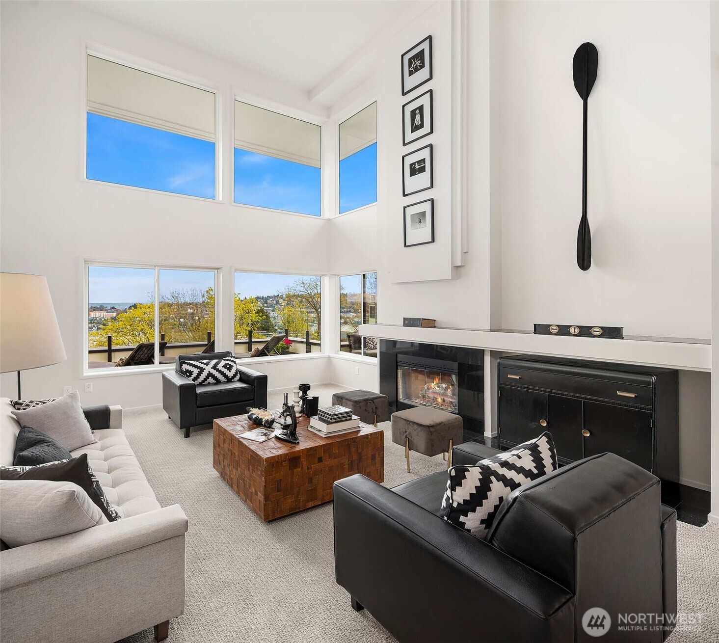 Cozy up in the spacious living room, featuring an oversized mantel and a wood-burning fireplace framed in sleek black tile.