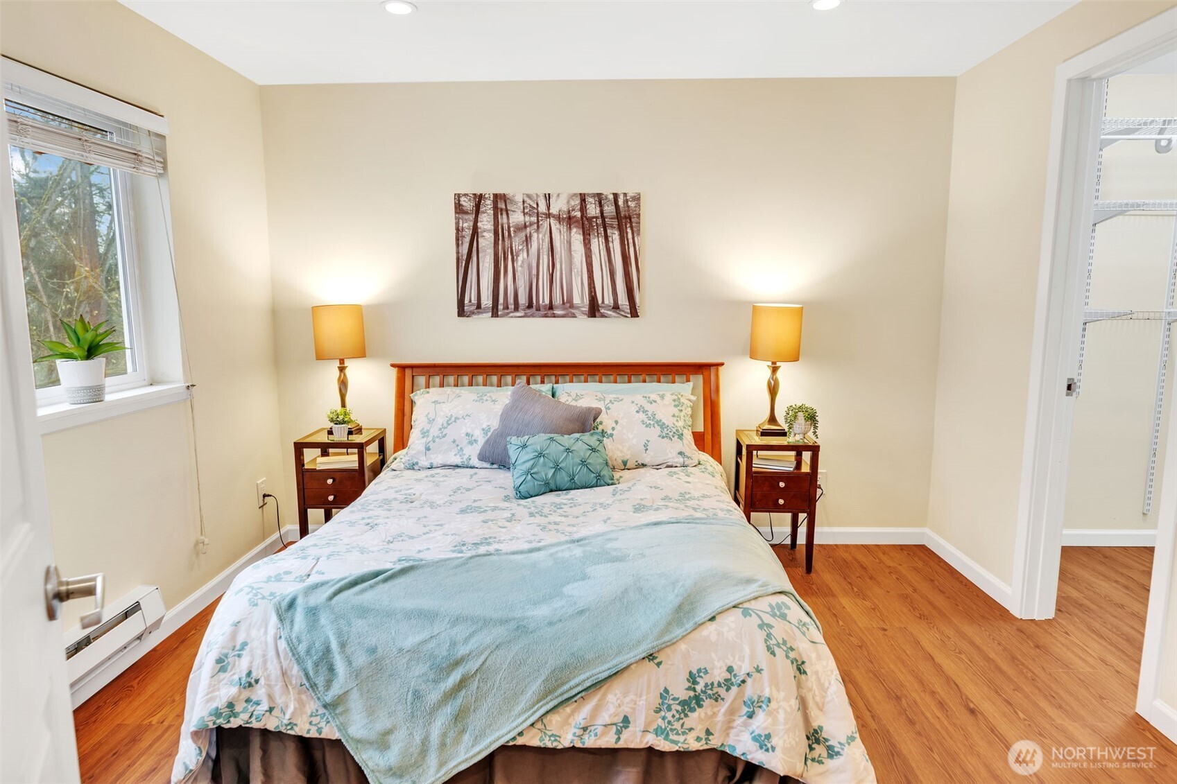 The primary bedroom has a window looking towards the greenbelt and shown on the right side of this photo, the entrance to the walk-in-closet.