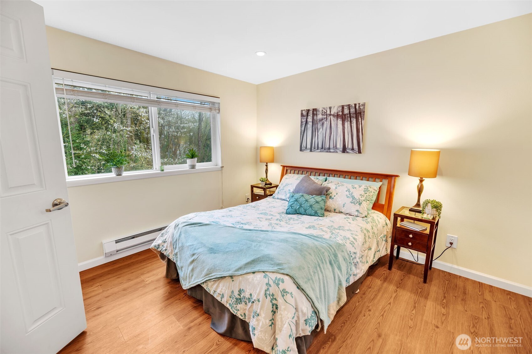 Another photo of the primary bedroom looking towards the greenbelt. In spring, there is a beautiful tree blooming outside this window.