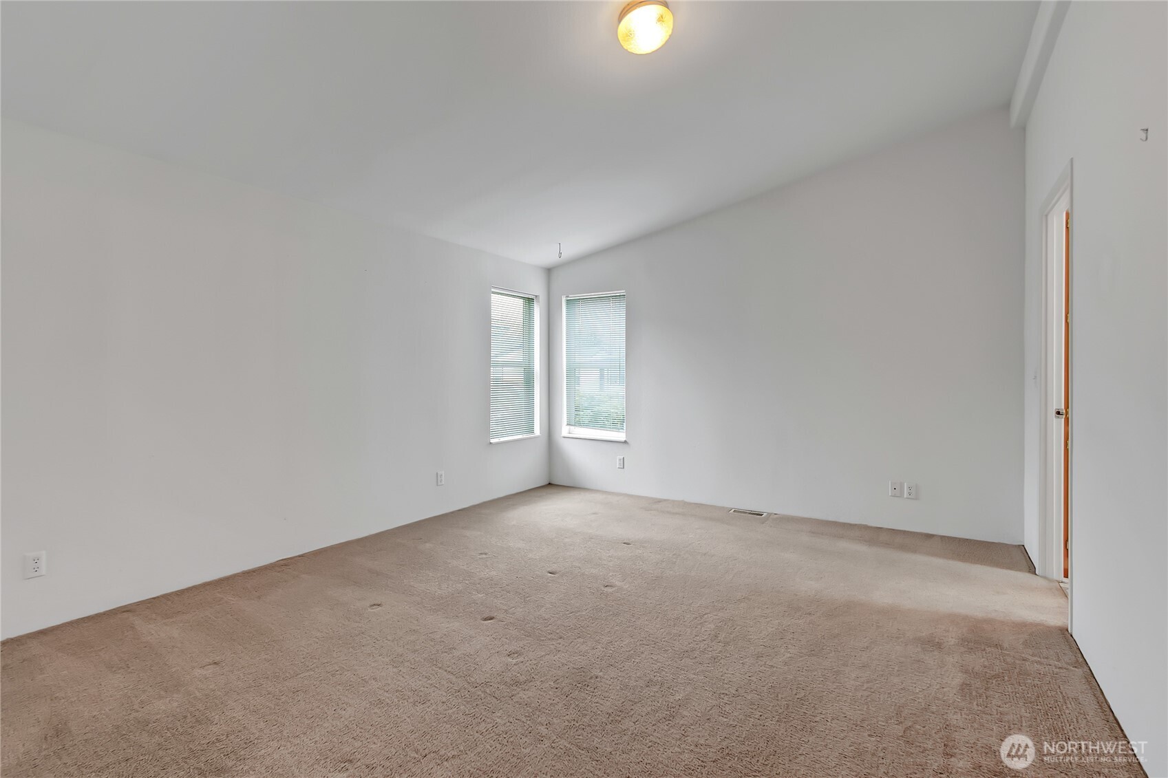 Primary suite that is currently unfurnished. Bath is through the doorway to the right.