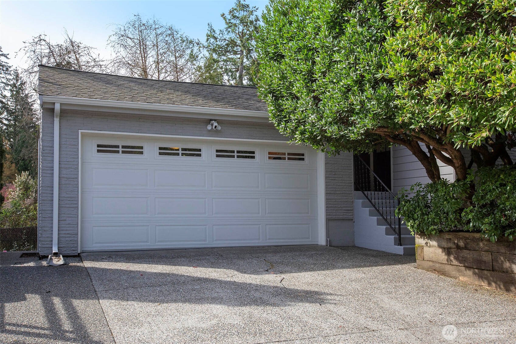 To the right of the garage is the stairway for the entrance to the kitchen. Spacious driveway.