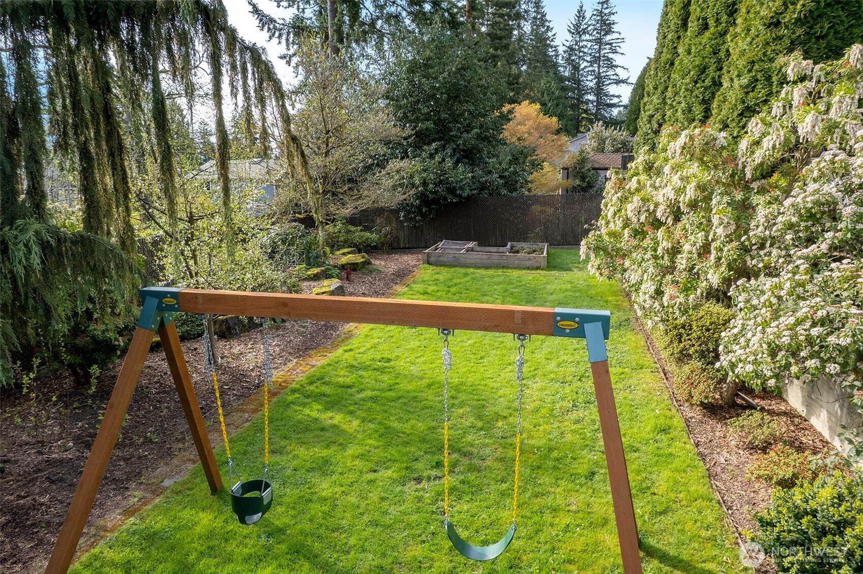 On the East side of the property is this fully fenced side yard. Lawn, planting beds, as well as a garden bed for veggies.