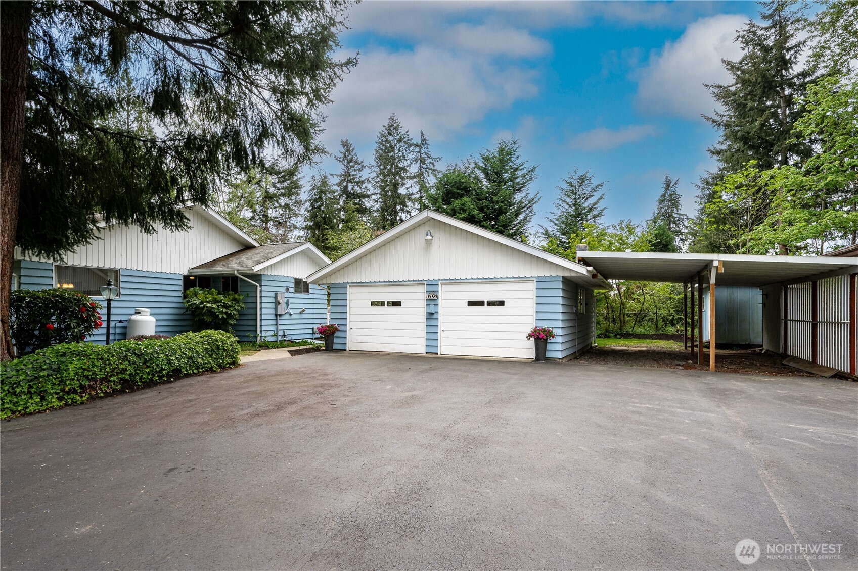 Expansive blacktop driveway, detached 2-car Garage (24'x28'), 2-bay carport (19.5'x29') and RV parking (not pictured here) (11'8"x 30')