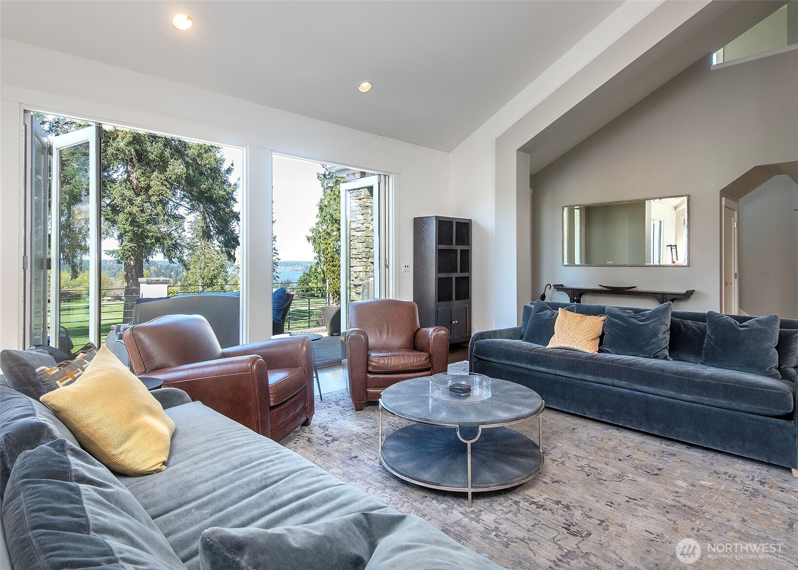 Enjoy seamless indoor/outdoor living with Marvin Ultimate Clad stacking doors, opening wide to connect the main living space with the front patio and stunning fairway views.