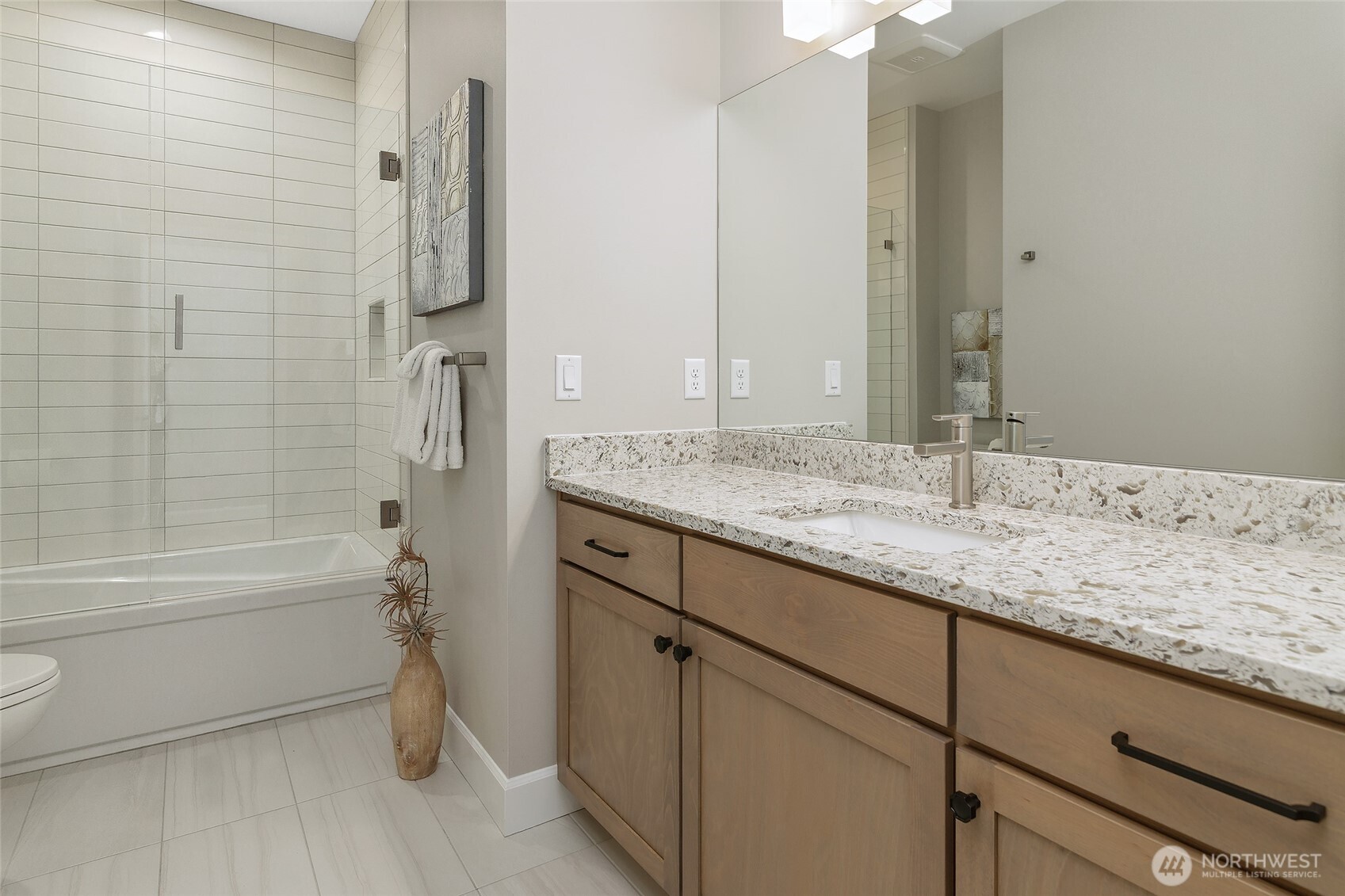 Conveniently situated between the two generous bedrooms, the stunning full-size bath showcases beautiful quartz countertops and tile work, along with the added touch of self-closing drawers and cabinets.