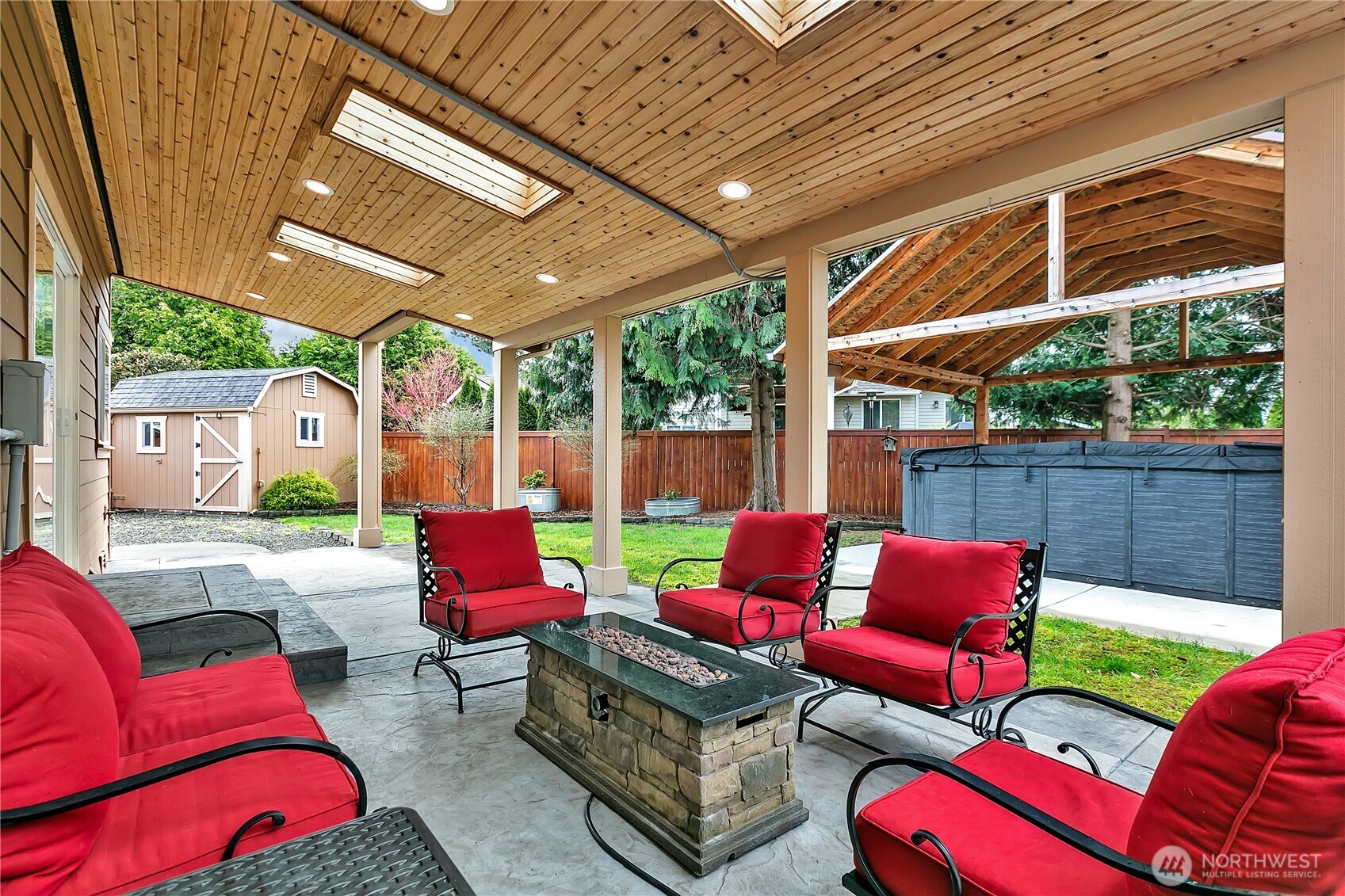 Skylights allow natural light to reach this amazing outdoor living space. The gas fire-pit and furniture convey with the home.