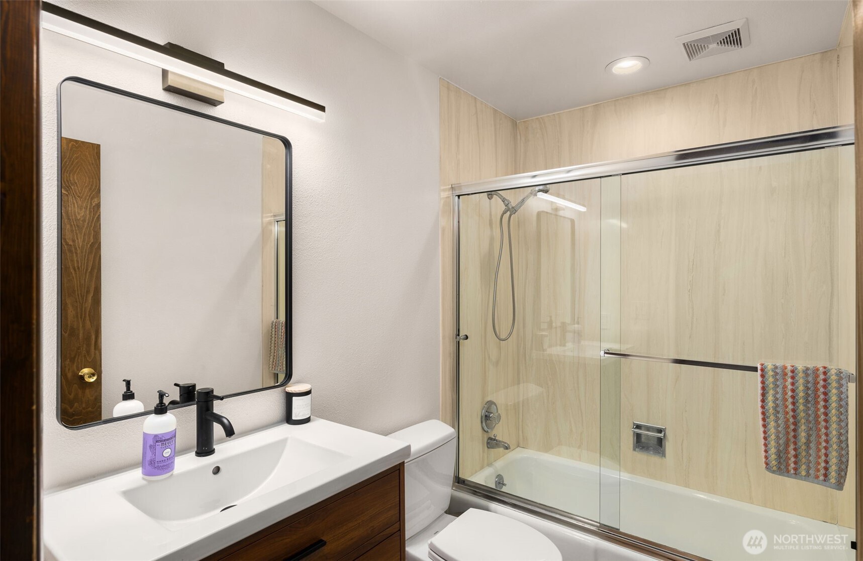 Main bathroom has updated vanity, lighting and flooring