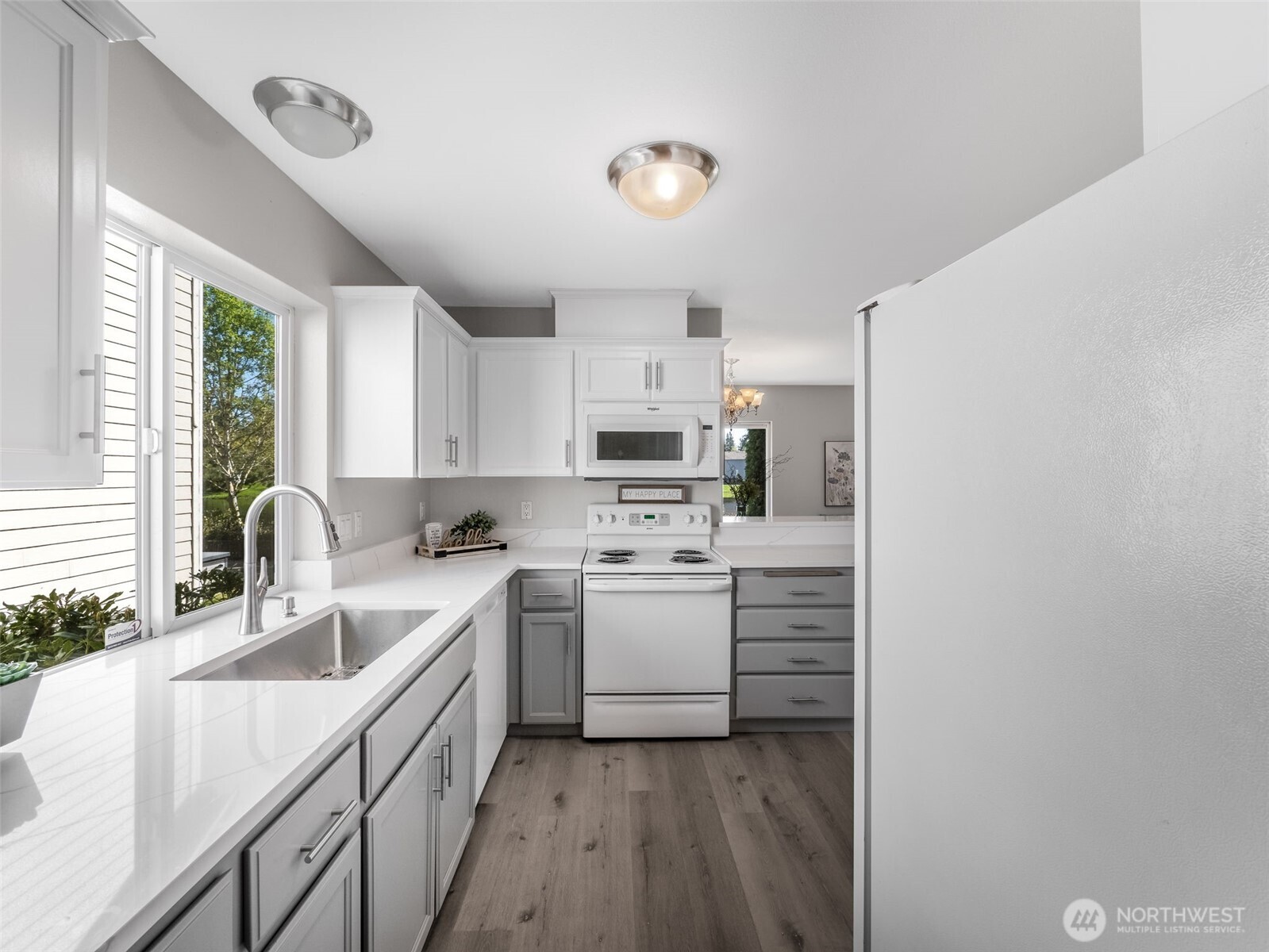 As you walk through the flex space you come to the updated kitchen with quartz countertops, backsplash, new sink, faucet, freshly painted cabinets and new flooring!