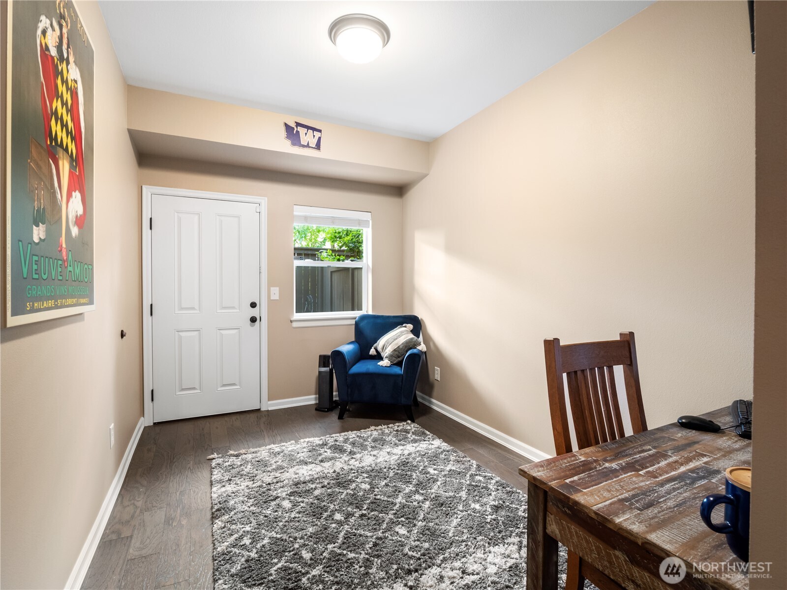 Downstairs, this cozy and inviting flex space perfect for a home office, reading nook, or guest retreat, with a large closet and access to the fenced back patio.