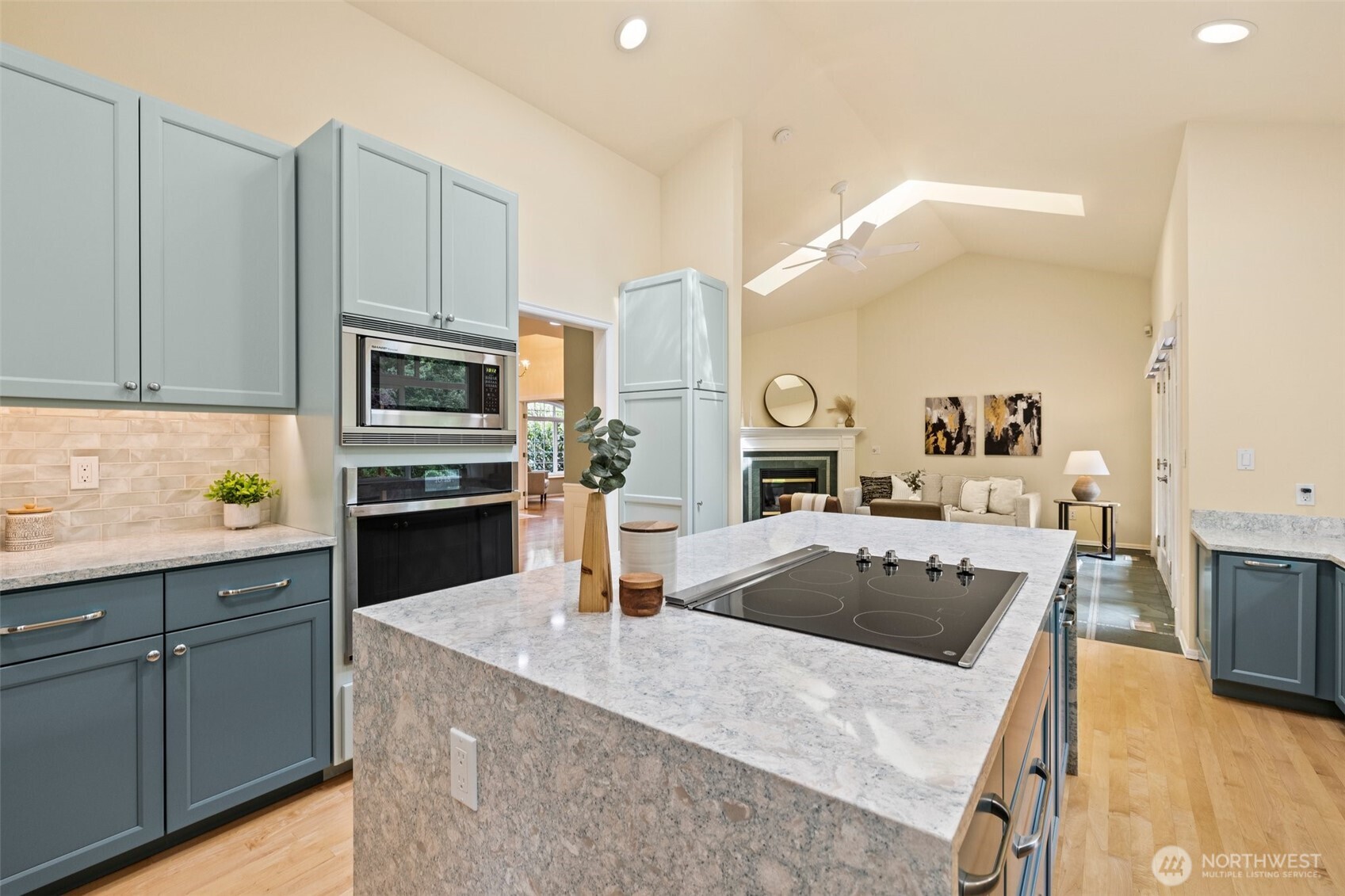 Beautifully remodeled kitchen with walk-in pantry, quartz countertops, plenty of cabinetry, stainless appliances and hardwood floors flows seemlessly into the family room. This is a one story rambler; so you could add a hood vent over the range quite easily if desired.