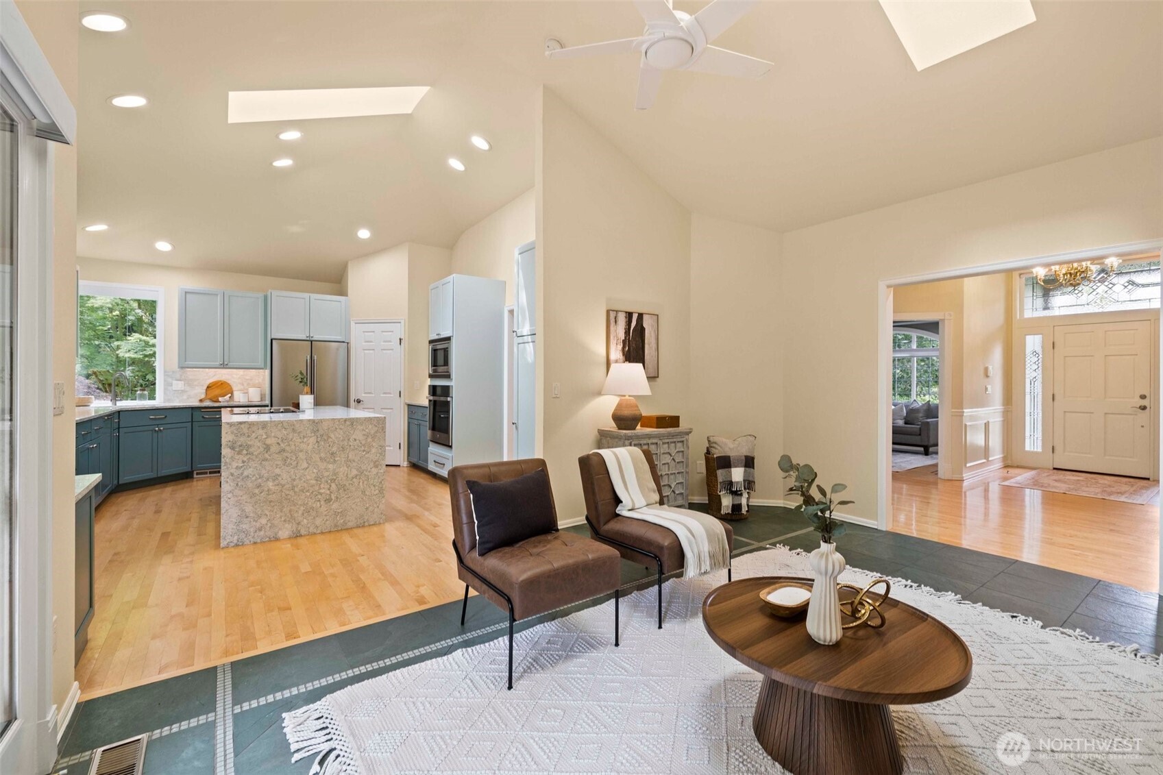 Family room off the kitchen with slate floors, gas fireplace, vaulted ceilings, skylight and French doors open to the backyard deck and large level backyard.