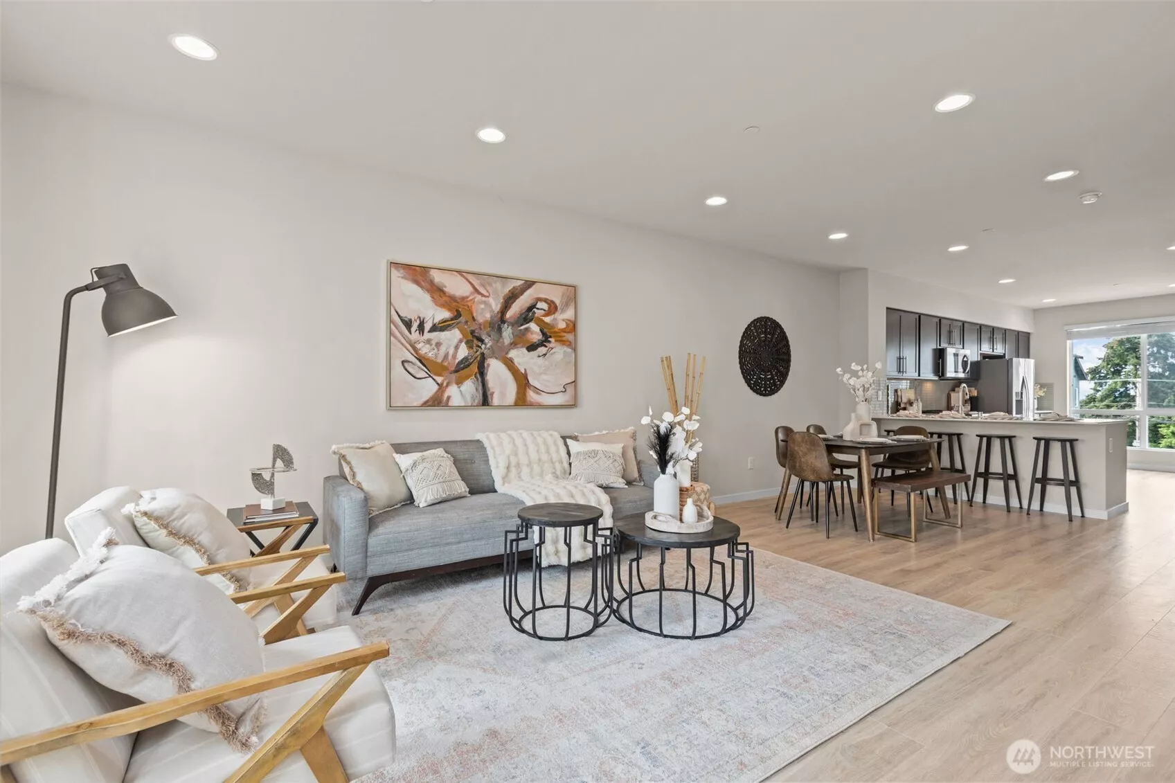 Bright and open living room with oversized windows, luxury vinyl plank flooring, and mini-split heating and A/C.