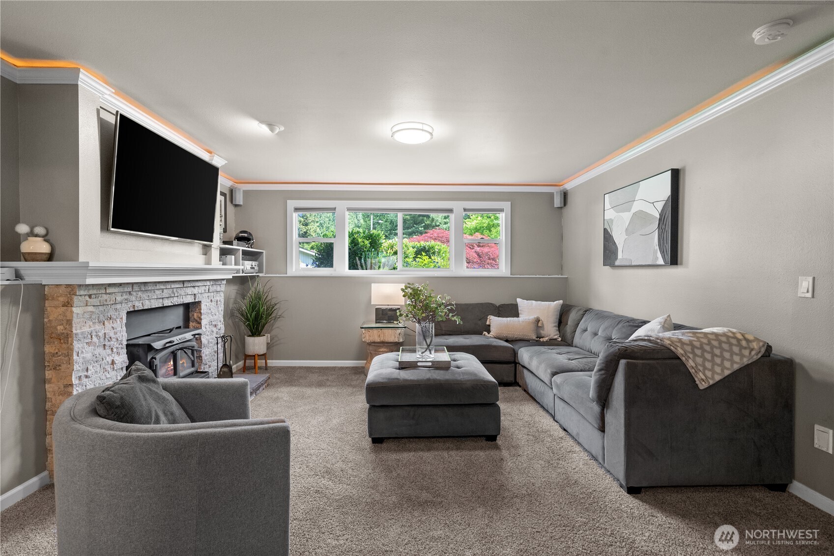 Head down to the lower level, where a spacious bonus room offers a private retreat—perfect for unwinding, cozying up by the wood-burning stove, or enjoying as a media room.