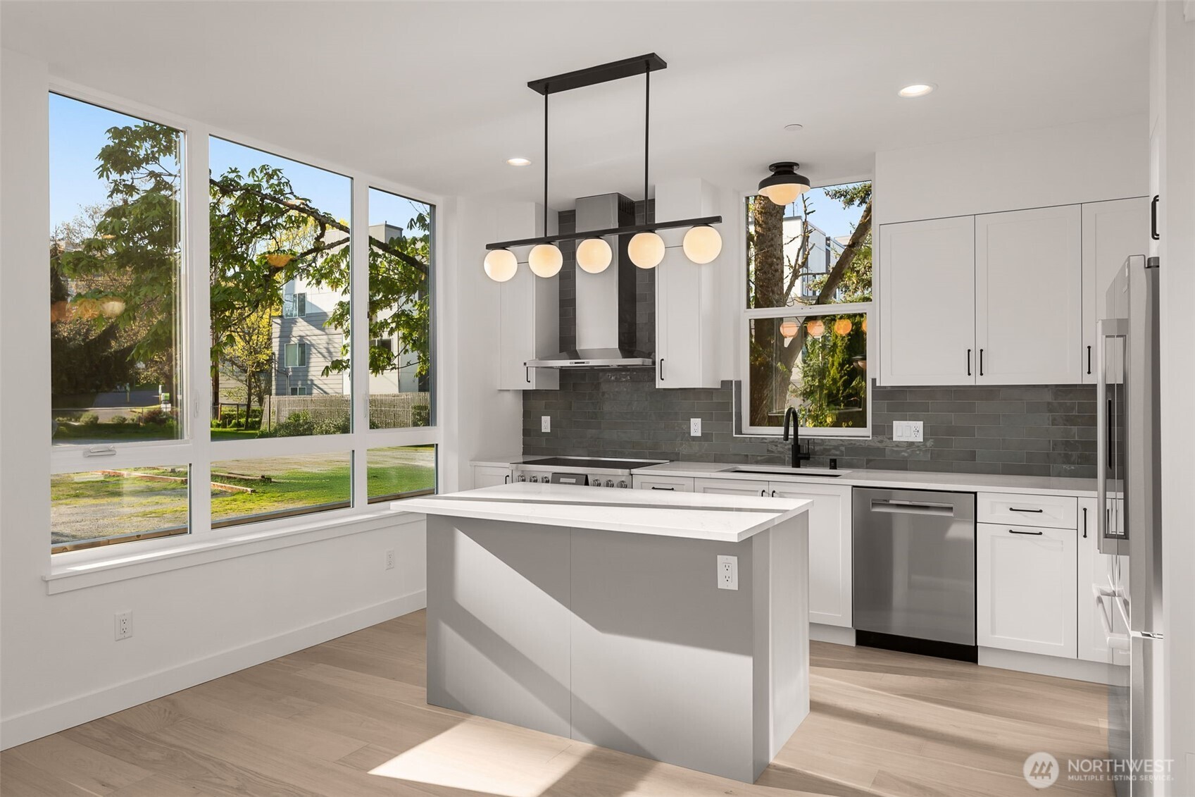 Sleek finishes and clean lines define this designer kitchen—complete with SS appliances, quartz counters, and plenty of prep space.