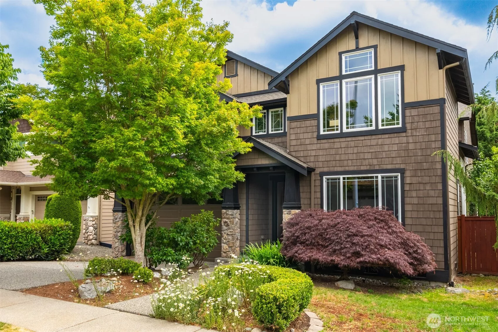 Charming curb appeal with craftsman details, stone accents, and mature shade trees — welcome home!