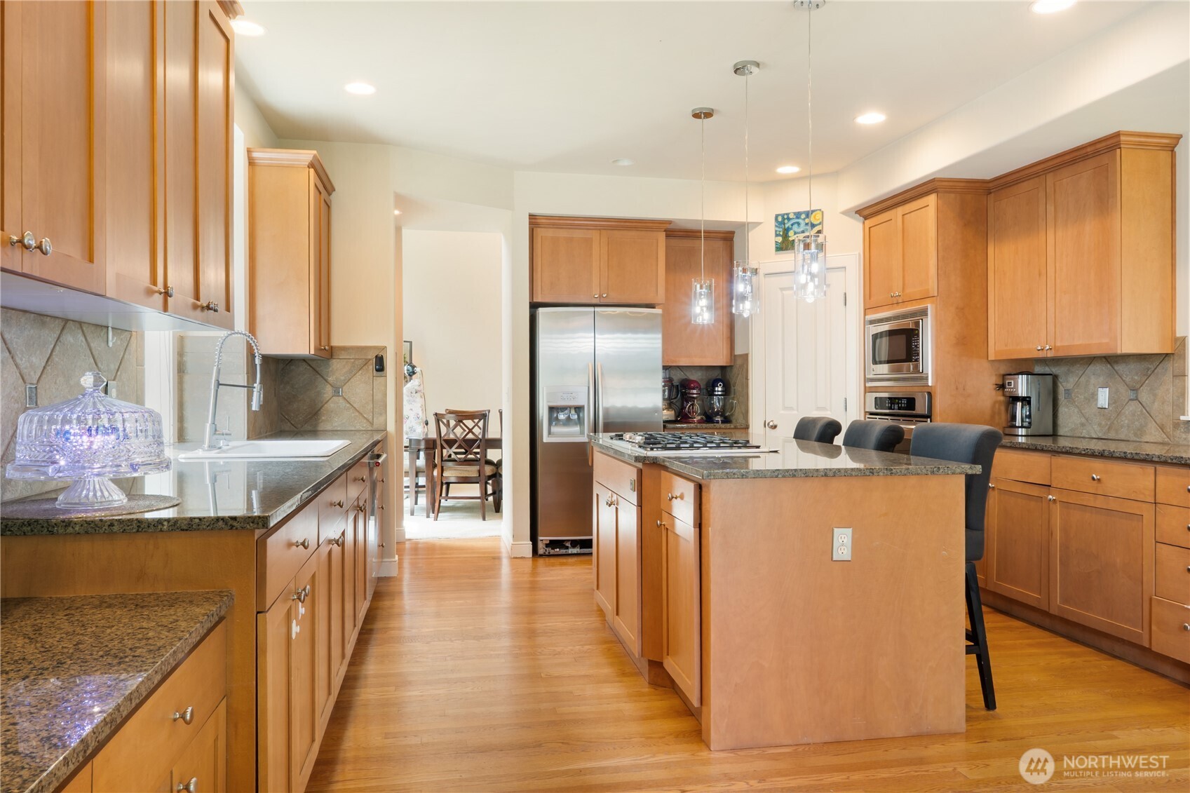 Gourmet kitchen features sleek stainless steel appliances, built-in microwave, and wall oven — ready for your culinary creations.