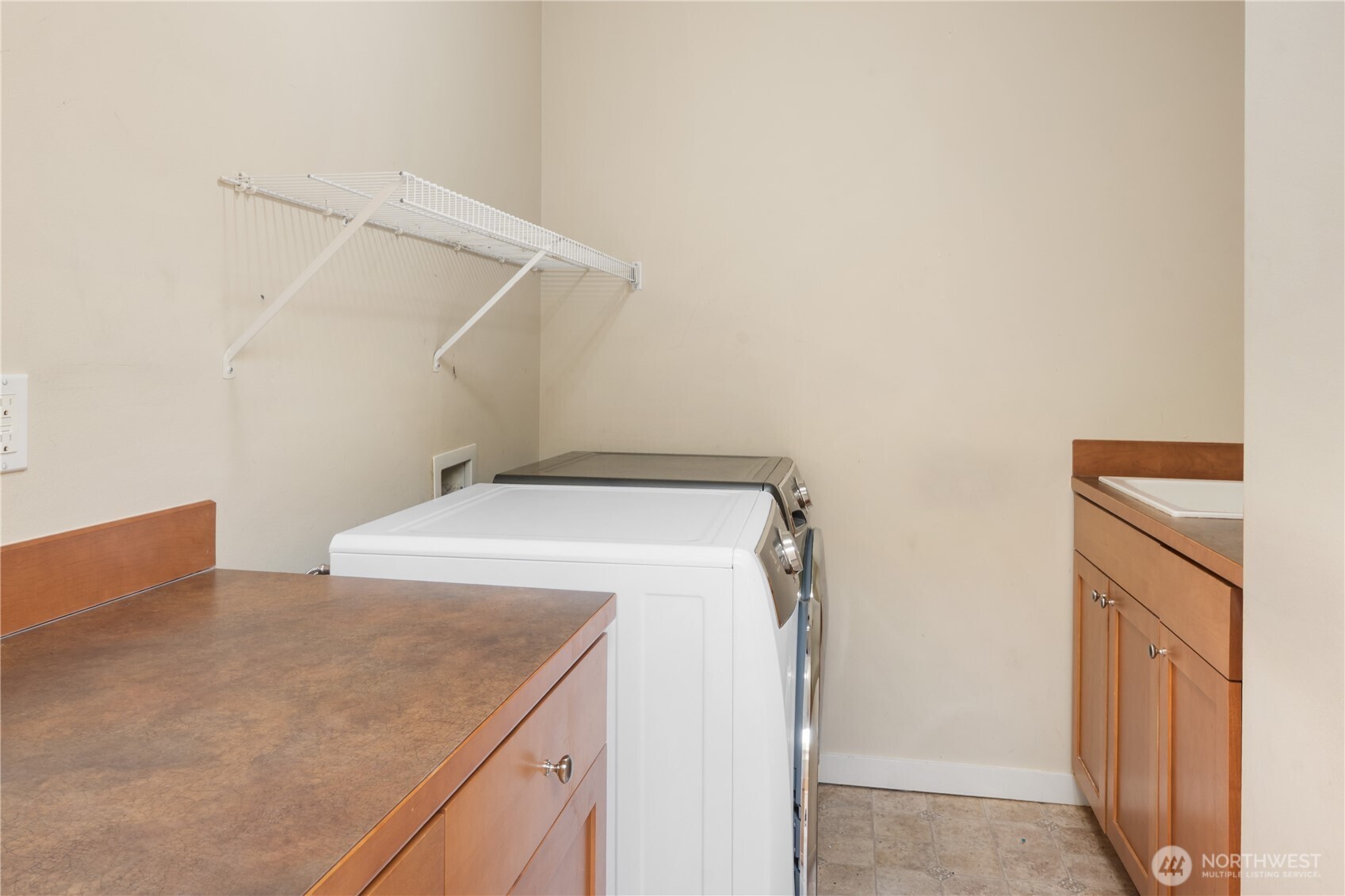 Dedicated laundry room with built-in cabinetry to keep household tasks organized. Don't miss the handy sink!