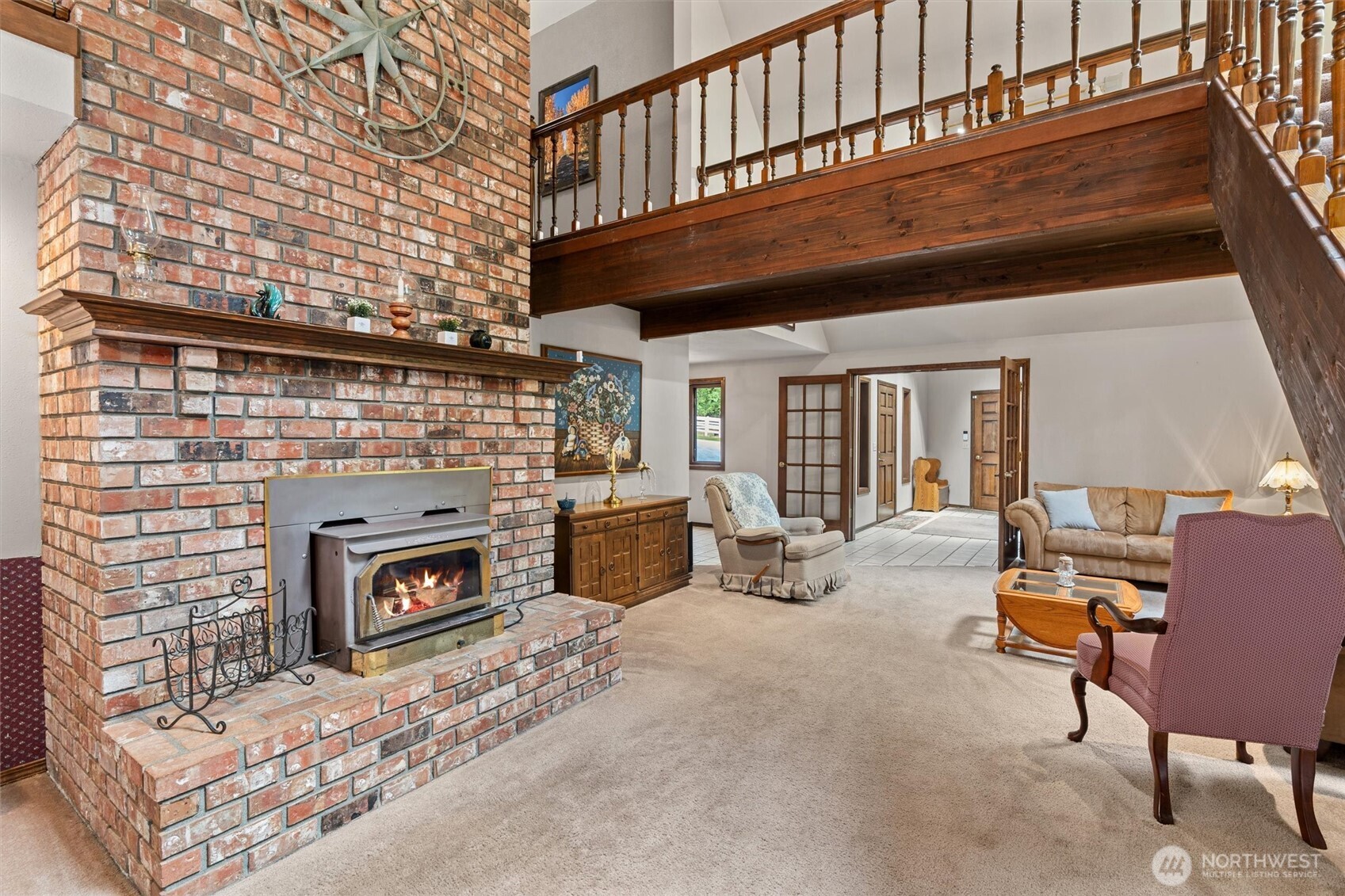 Spacious living area featuring a wood-burning masonry fireplace with two story brick chimney