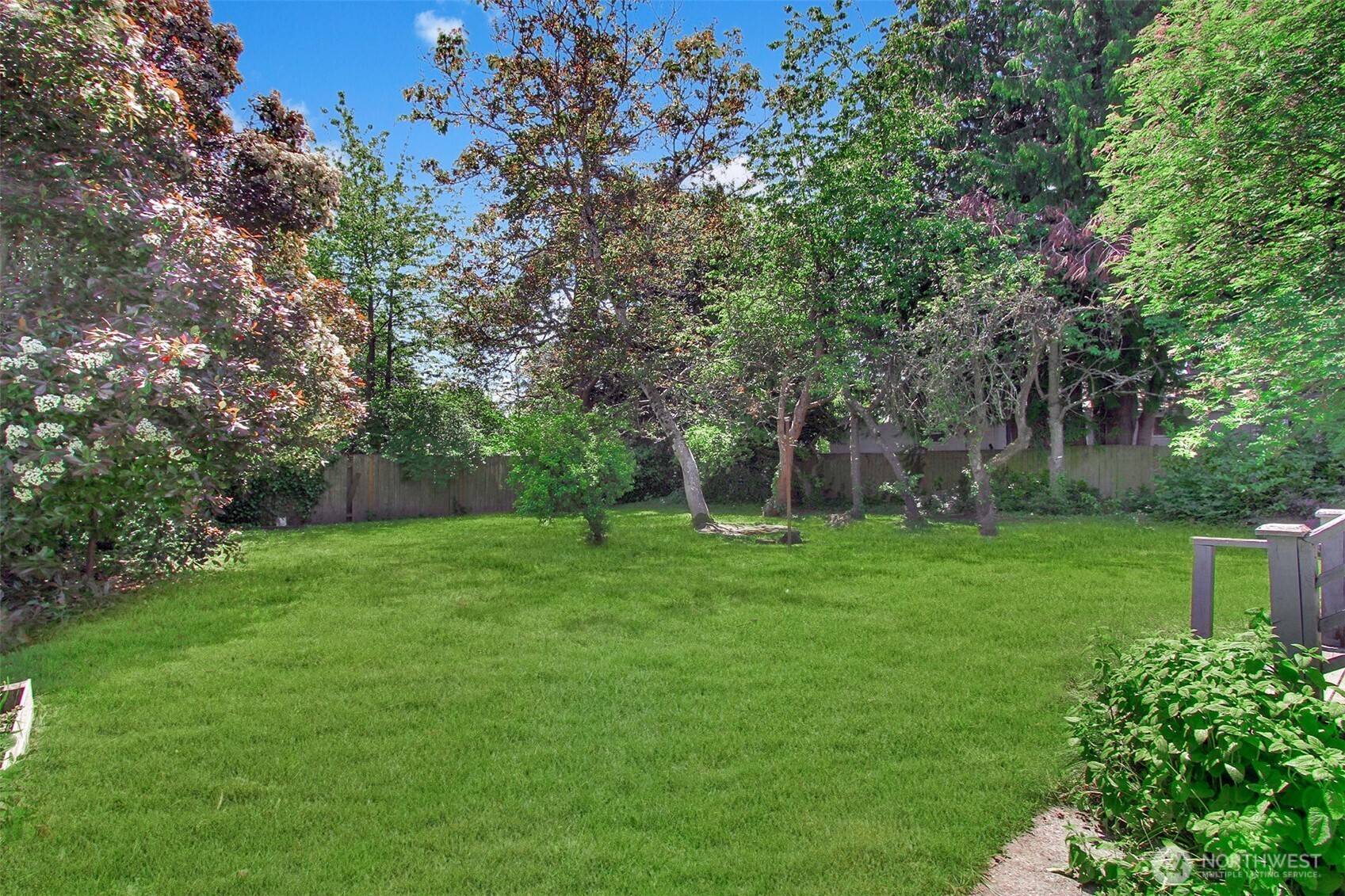 Back of the house. Charming backyard! Blooming hydrangeas and rhodedendrons! Raised flower beds. Big side yard with gate. Fully fenced. Very private and homey. Great for pets, play and entertaining!